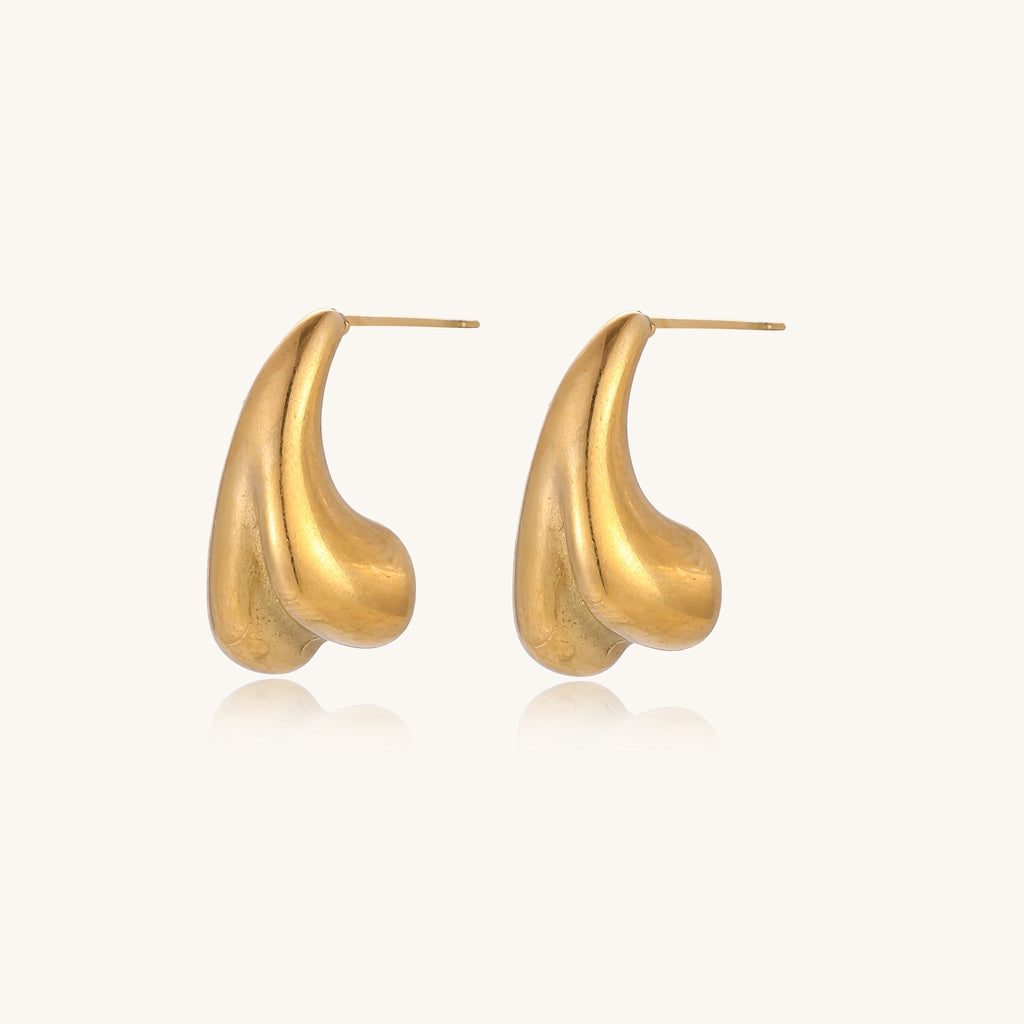 Pair of gold-plated sculptural stud earrings with organic teardrop shapes on neutral background.